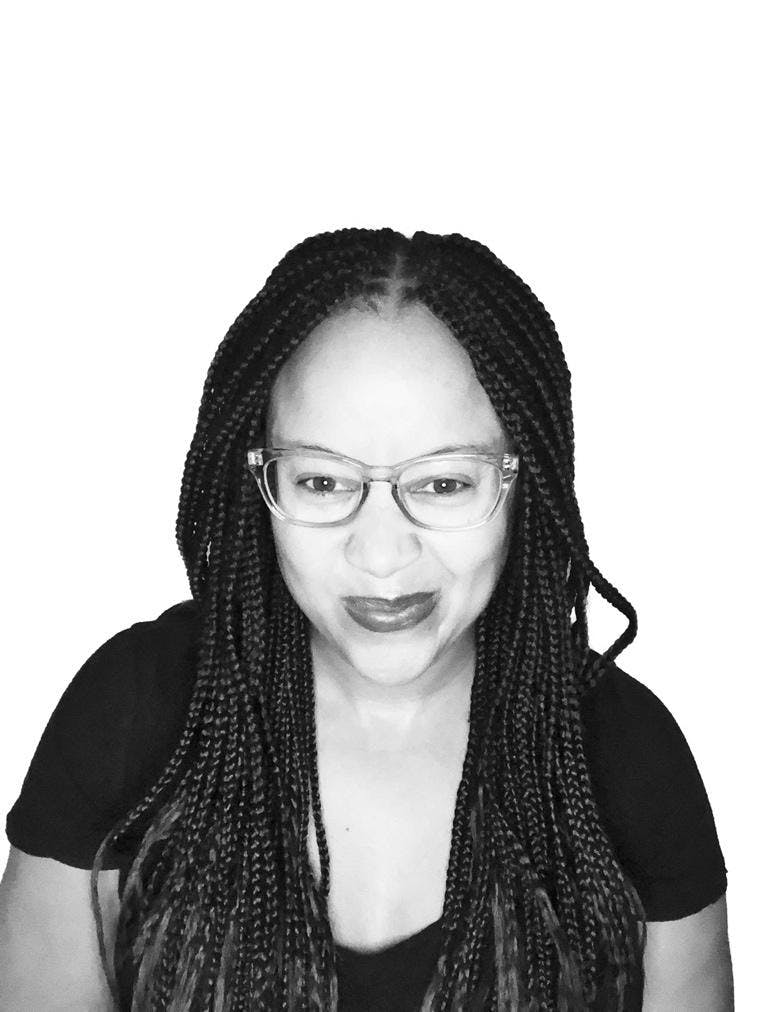 Black and white headshot of Dhonielle Clayton, smiling woman of color with glasses and long braids